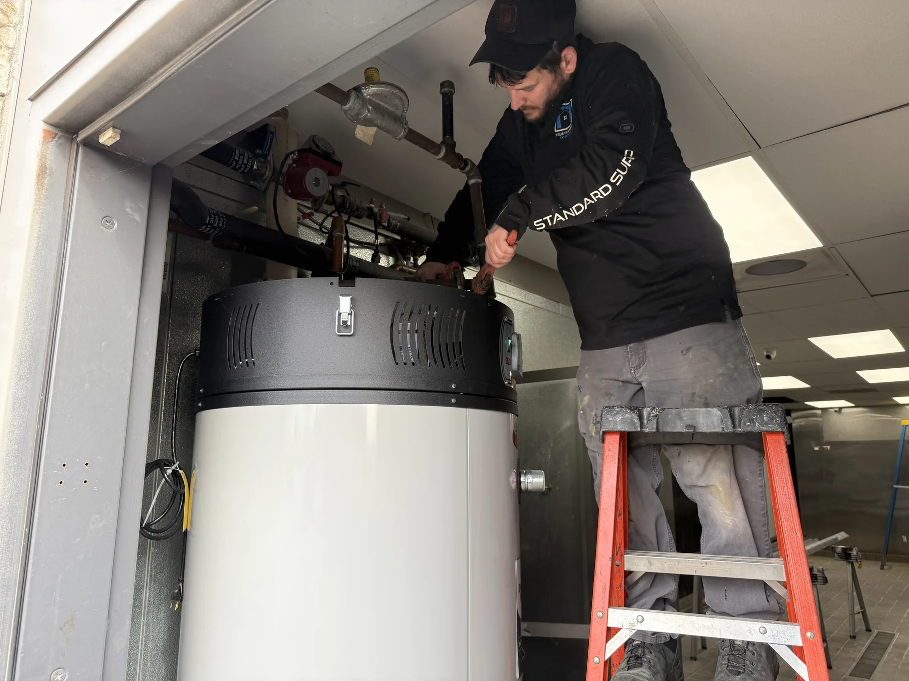 True Plumbing technician installing a commercial water heater