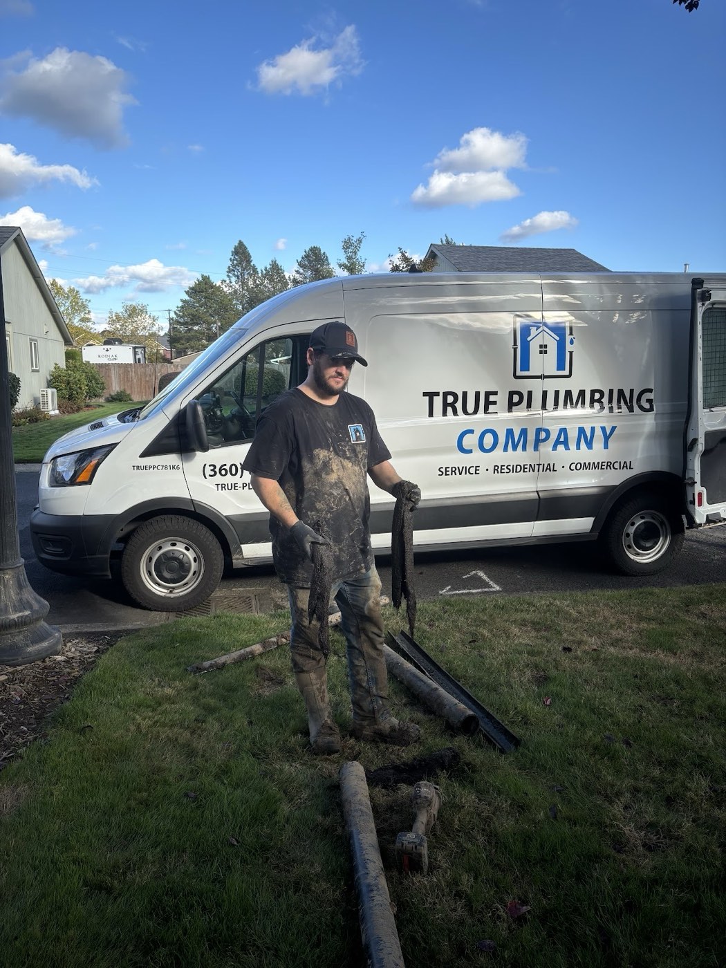 True Plumbing technician and service van on a muddy job